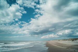 Cloudy sky over serene beach at low tide with gentle waves lapping at the shore photo