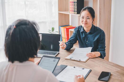 HR managers are interviewing job applicants who fill out their resume on the job application form in order to consider accepting a job as a company photo