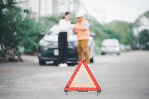 red emergency triangle on the road indicates that there is an accident or car breakdown on the road ahead. photo