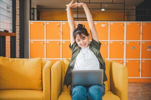 Young Asian freelancers are stretching oneself and relaxing after working and planning to work while working on laptop in the cafe photo