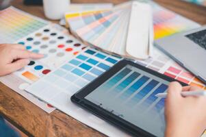 Graphic designer architects who work with laptops and color comparison tables for design work. photo