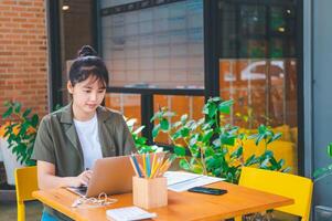Freelance worker working on documents with graphs. and information about finances on laptops in cafes photo