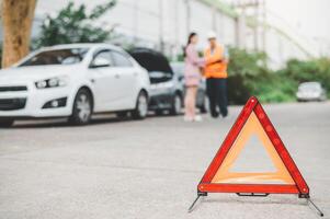 red emergency triangle on the road indicates that there is an accident or car breakdown on the road ahead. photo