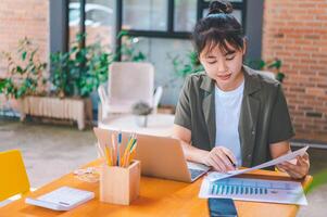 Freelance worker working on documents with graphs. and information about finances on laptops in cafes photo