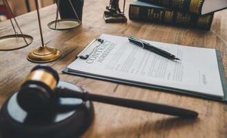 The contract agreement book is on the table, along with the judge's hammer.The judge's mallet, law enforcement personnel, evidence-based cases, and papers were all considered. photo