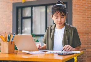 Freelance worker working on documents with graphs. and information about finances on laptops in cafes photo
