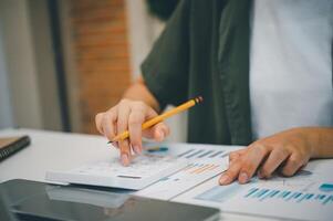 Freelance worker working on documents with graphs. and information about finances on laptops in cafes photo