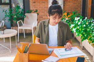 Freelance worker working on documents with graphs. and information about finances on laptops in cafes photo