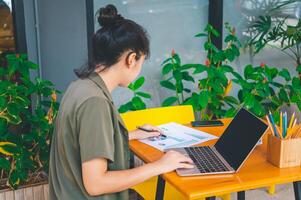 Freelance worker working on documents with graphs. and information about finances on laptops in cafes photo