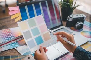 Graphic designer architects who work with laptops and color comparison tables for design work. photo