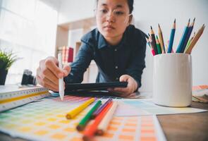 Graphic designer architects who work with laptops and color comparison tables for design work. photo