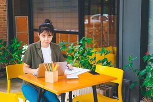 Freelance worker working on documents with graphs. and information about finances on laptops in cafes photo