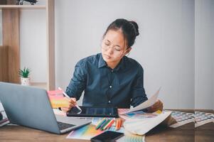 Graphic designer architects who work with laptops and color comparison tables for design work. photo