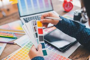 Graphic designer architects who work with laptops and color comparison tables for design work. photo