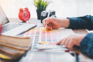 Graphic designer architects who work with laptops and color comparison tables for design work. photo