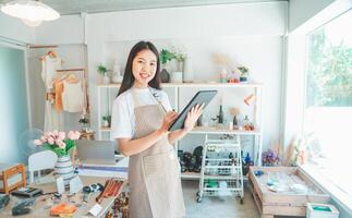 Small business owners are preparing a small shop and checking through a tablet and checking orders. photo