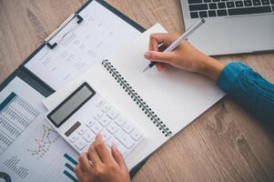 close up The business person is sitting on a calculator with a graph in the office of finance accounting concept photo