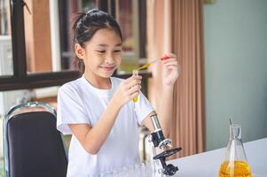 little scientist looking through a microscope and test tubes filled with chemicals for learning about science and experiments. photo