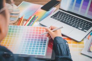 Graphic designer architects who work with laptops and color comparison tables for design work. photo