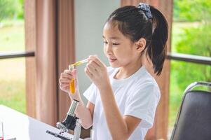 little scientist looking through a microscope and test tubes filled with chemicals for learning about science and experiments. photo