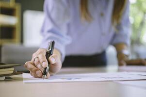 businessman pointing with pen on business report chart are working on accounts in business analysis with graphs and documentation. photo