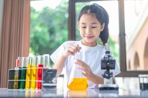 little scientist looking through a microscope and test tubes filled with chemicals for learning about science and experiments. photo