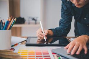 Graphic designer architects who work with laptops and color comparison tables for design work. photo