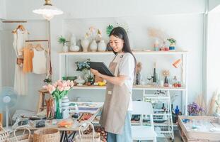 Small business owners are preparing a small shop and checking through a tablet and checking orders. photo