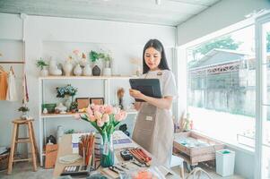 Small business owners are preparing a small shop and checking through a tablet and checking orders. photo