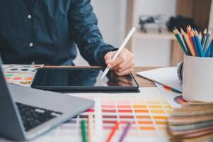 Graphic designer architects who work with laptops and color comparison tables for design work. photo