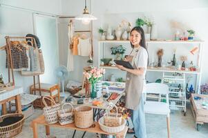 Small business owners are preparing a small shop and checking through a tablet and checking orders. photo