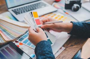 Graphic designer architects who work with laptops and color comparison tables for design work. photo