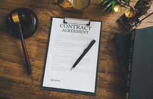The contract agreement book is on the table, along with the judge's hammer.The judge's mallet, law enforcement personnel, evidence-based cases, and papers were all considered. photo
