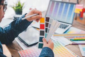 Graphic designer architects who work with laptops and color comparison tables for design work. photo