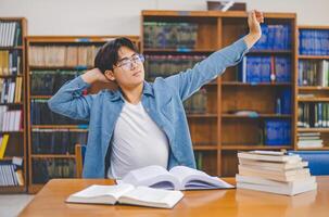 Students are relaxing after working on their laptops and searching for books to study, make reports, find useful information in the university room. photo