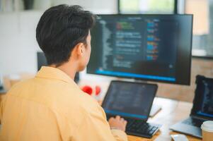 Young programmer working on coding, software development and web design in software company office.Concept technology development photo