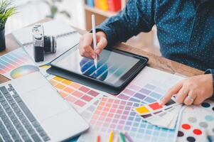Graphic designer architects who work with laptops and color comparison tables for design work. photo