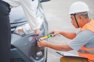 male insurance officer came to help inspect a customer's car that had an accident. Concept for vehicle crash, insurance claim. photo