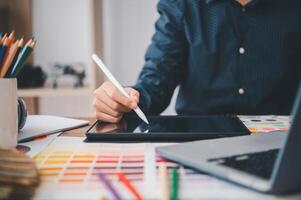 Graphic designer architects who work with laptops and color comparison tables for design work. photo