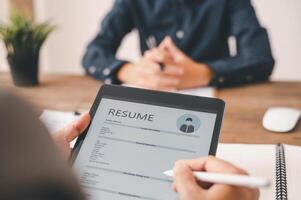 HR managers are interviewing job applicants who fill out their resume on the job application form in order to consider accepting a job as a company photo