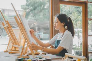 Art student drawing with watercolor painting on canvas doing some art projects on studio workshop photo