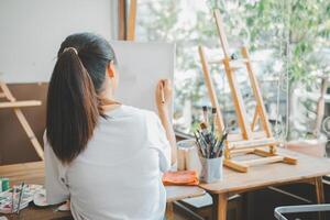 Art student drawing with watercolor painting on canvas doing some art projects on studio workshop photo