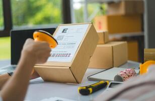 online small business owner scans a barcode-labeled parcel with a barcode scanner to verify a customer's order before it is delivered to the customer. photo