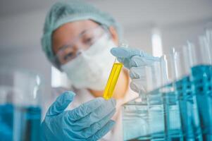 Female researchers are experimenting with pipette dropping a sample into a test tube in an experiment research in laboratory.. photo