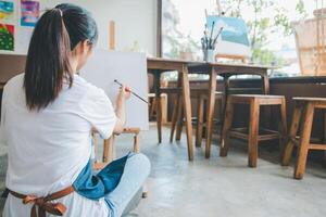 Art student drawing with watercolor painting on canvas doing some art projects on studio workshop photo