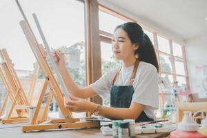 Art student drawing with watercolor painting on canvas doing some art projects on studio workshop photo