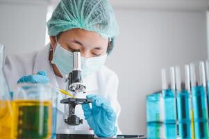 Female researchers are experimenting with pipette dropping a sample into a test tube in an experiment research in laboratory.. photo