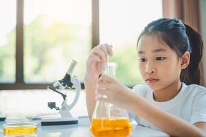 little scientist looking through a microscope and test tubes filled with chemicals for learning about science and experiments. photo