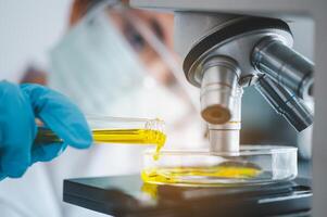 Female researchers are experimenting with pipette dropping a sample into a test tube in an experiment research in laboratory.. photo