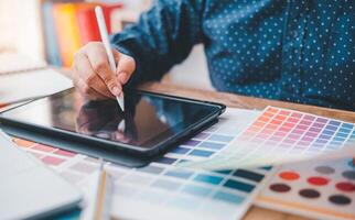 Graphic designer architects who work with laptops and color comparison tables for design work. photo